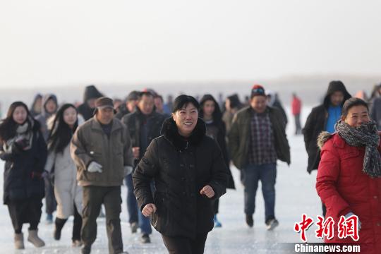 800余名冰上马拉松竞赛选手 “全副武装”前行，他们在千里冰封的博斯腾湖面上划出一条闪亮的轨迹。　年磊 摄