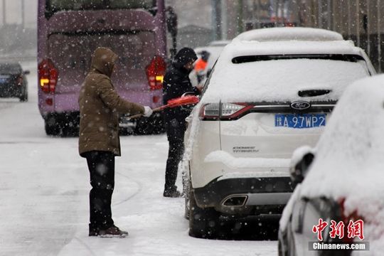 河南迎降雪天气 民众冒雪拎行李箱出行