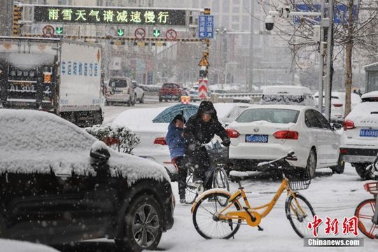 河南迎降雪天气 民众冒雪拎行李箱出行