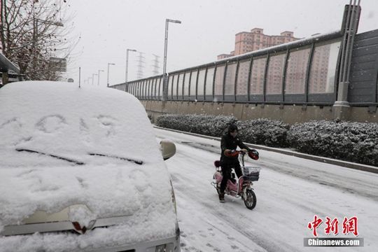 河南迎降雪天气 民众冒雪拎行李箱出行